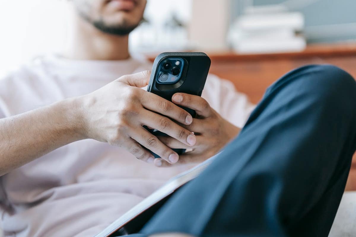 Cilvēks aizpilda pieteikumu telefonā